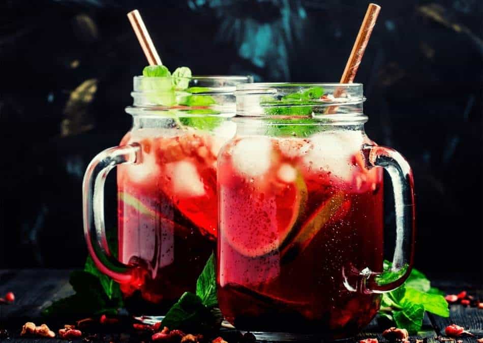 passion tea lemonade in two mason jars with straws and mint leaves