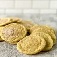 MATCHA SNICKERDOODLE COOKIES ON A CEMENT SURFACE WITH WHITE TILE BACKGROUND