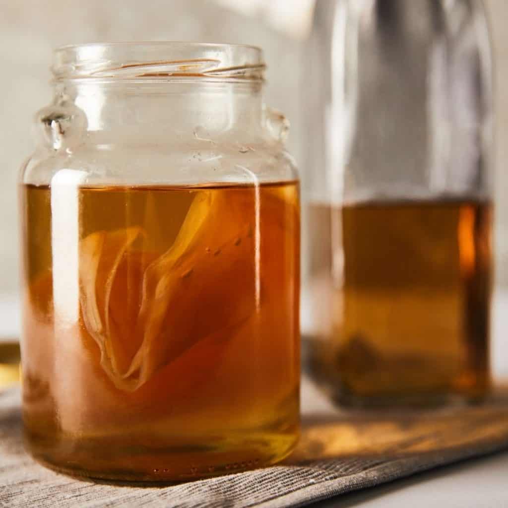 kombucha tea in a glass jar with a scabby