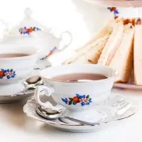 teacup with teaspoon and finger sandwiches